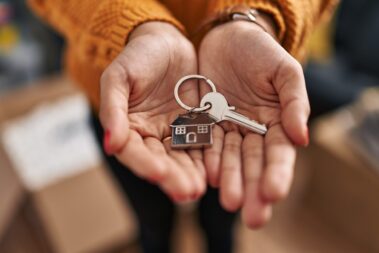 Young woman holding key of new house at new home